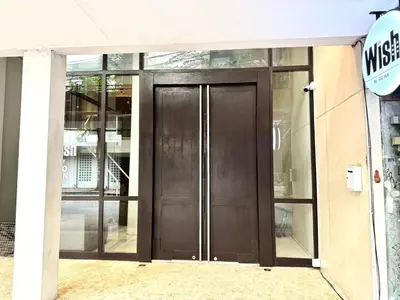 a brown door on a building with glass windows at Wish Inn Silom - วิช อินน์ สีลม in Bang Rak