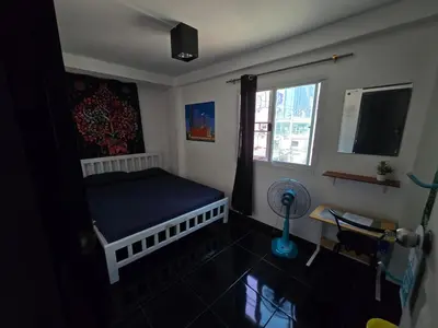 a bedroom with a bed and a window and a fan at Jatujak Bangkok guesthouse R 03-06 in Sathani Bang Su