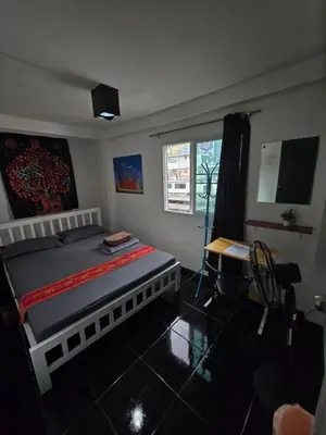 a bedroom with a bed and a desk and a television at Jatujak Bangkok guesthouse R 03-06 in Sathani Bang Su