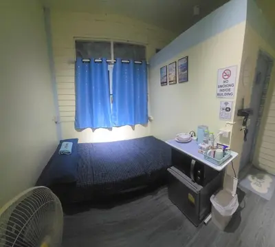 a small bedroom with a blue bed and a window at 209 Beautiful and Cozy apartment near skytrain & WiFi in Bangkok