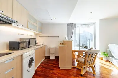 a kitchen with a washing machine and a table with a chair at 2Br, Good view, BTS Chitlom, BKK in Bangkok