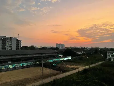 a sunset over a city with a train station at Ordinary Salaya in Sathani Sala Ya