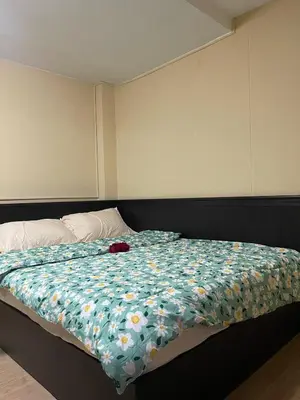 a bedroom with a bed with a flowery comforter at Ordinary Salaya in Sathani Sala Ya
