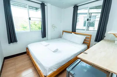 a small room with a bed and two windows at xx GO INN The Giant Swing เสาชิงช้า กรุงเทพ in Bangkok