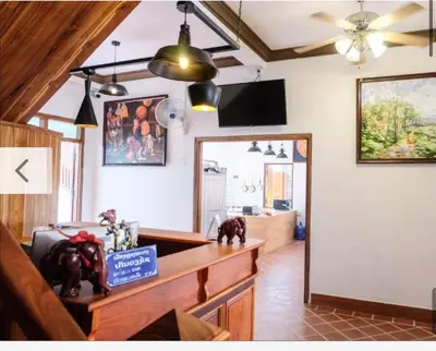 a living room with a table and a mirror at Laung Prabang museum inn& travel in Bang Su