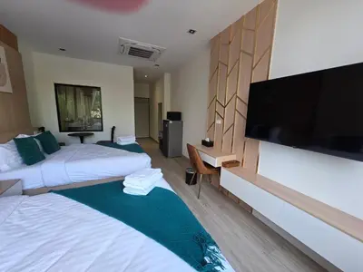 a hotel room with two beds and a flat screen tv at Diff Apartel Banglamphu in Bangkok