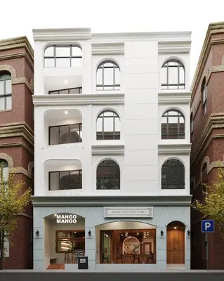 a white building with windows on a street at Diff Apartel Banglamphu in Bangkok