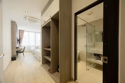 a bathroom with a glass door leading to a bedroom at Diff Apartel Banglamphu in Bangkok