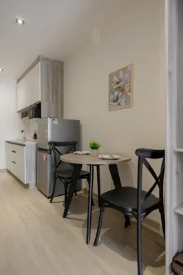 a kitchen with a table and chairs in a room at Diff Apartel Banglamphu in Bangkok