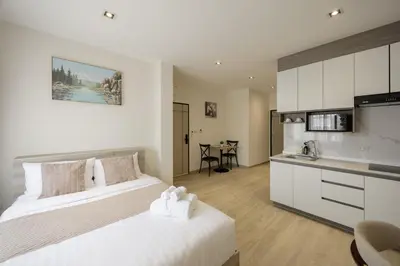 a hotel room with a bed and a kitchen at Diff Apartel Banglamphu in Bangkok
