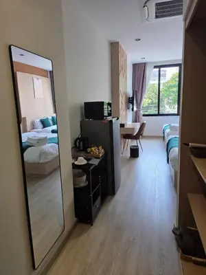 a hotel room with a mirror and a bedroom at Diff Apartel Banglamphu in Bangkok