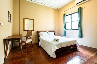 a bedroom with a bed and a desk and a window at Rest Inn China Town - Yaowarat BKK in Samphanthawong