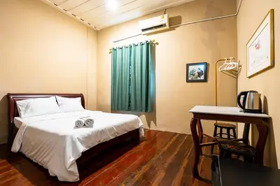 a bedroom with a bed and a desk and a table at Rest Inn China Town - Yaowarat BKK in Samphanthawong