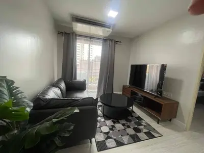 a living room with a couch and a tv at MeStlye BangNa - Baan Win in Bangna