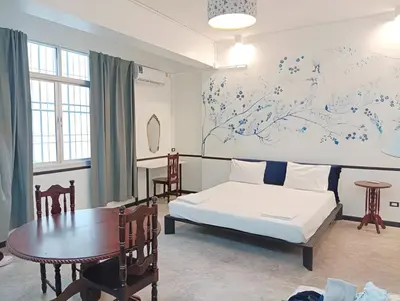 a bedroom with a bed and a table and a table sidx sidx sidx at xx The Character Yaowarat เดอะ คาแรคเตอร์ เยาวราช ตรอกข้าวสาร in Samphanthawong