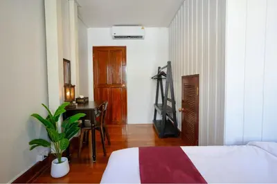 a bedroom with a bed and a desk and a table at Nivas Wanit 2BR 1SFB Yaowarat MRT EntireHome 80SQM in Bangkok