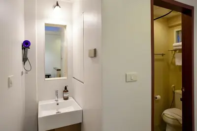 a bathroom with a sink and a mirror and a toilet at Nivas Wanit 2BR 1SFB Yaowarat MRT EntireHome 80SQM in Bangkok