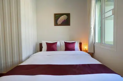 a bedroom with a large white bed with red pillows at Nivas Wanit 2BR 1SFB Yaowarat MRT EntireHome 80SQM in Bangkok