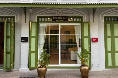 a store front with green doors and two plants at Nivas Wanit 2BR 1SFB Yaowarat MRT EntireHome 80SQM in Bangkok
