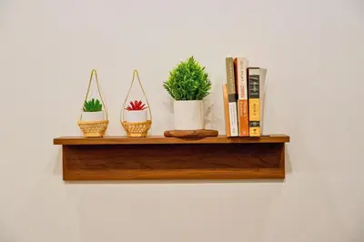 a shelf with three potted plants and books on it at Nivas Wanit 3BR 1SFB Yaowarat MRT EntireHome 85SQM in Bangkok