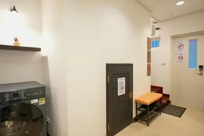 a room with a washing machine and a stool at Nivas Wanit 3BR 1SFB Yaowarat MRT EntireHome 85SQM in Bangkok