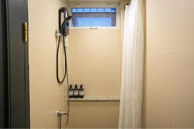 a shower with a shower curtain and a window at Nivas Wanit 3BR 1SFB Yaowarat MRT EntireHome 85SQM in Bangkok