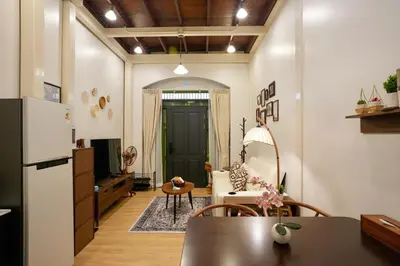 a kitchen and living room with a table and a refrigerator at Nivas Wanit 3BR 1SFB Yaowarat MRT EntireHome 85SQM in Bangkok