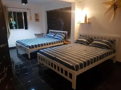 two beds sitting in a room with at Jatujak Bangkok guesthouse in Sathani Bang Su