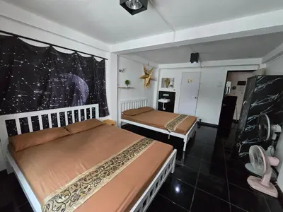 a bedroom with two beds and a large window at Jatujak Bangkok guesthouse in Sathani Bang Su