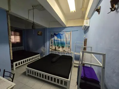 a bedroom with two beds and a blue wall at Jatujak Bangkok guesthouse in Sathani Bang Su