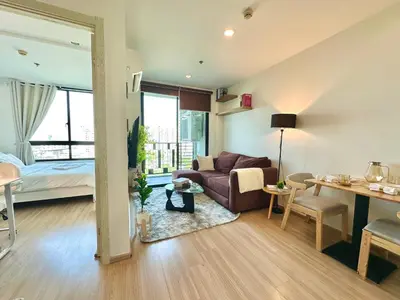 a living room with a couch and a bedroom at Cosy & Bright 1 bedroom in Bangkok