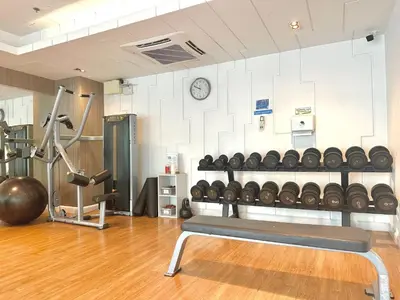 a room with a gym with a bench and weights at Cosy & Bright 1 bedroom in Bangkok