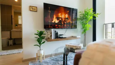 a living room with a fireplace and a tv on the wall at Cosy & Bright 1 bedroom in Bangkok