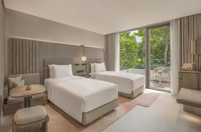 a hotel room with two beds and a window at Kromo Bangkok, Curio Collection By Hilton in Bangkok