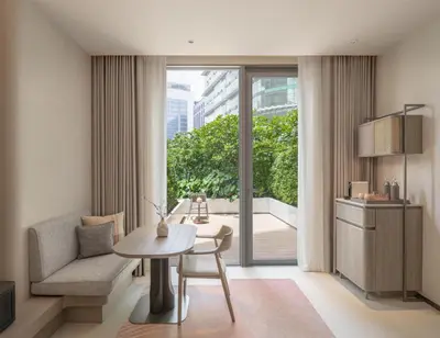 a living room with a table and a chair at Kromo Bangkok, Curio Collection By Hilton in Bangkok