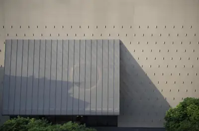 a building with a reflection of a cloud in the windows at Kromo Bangkok, Curio Collection By Hilton in Bangkok