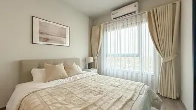 a bedroom with a bed and a large window at New 1-Bedroom Condo for Rent 0 Meters from BTS Wutthakat in Bang Khun Thian