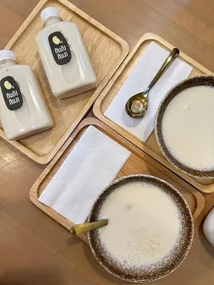 three containers of milk and a spoon on a table at New 1-Bedroom Condo for Rent 0 Meters from BTS Wutthakat in Bang Khun Thian