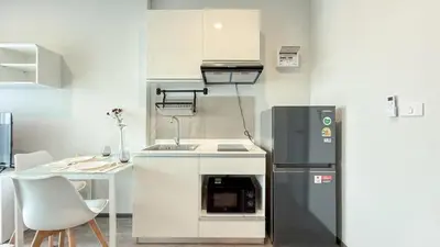 a small kitchen with a sink and a refrigerator at New 1-Bedroom Condo for Rent 0 Meters from BTS Wutthakat in Bang Khun Thian