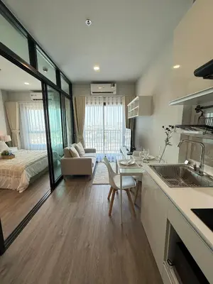 a kitchen and living room with a bed and a table at New 1-Bedroom Condo for Rent 0 Meters from BTS Wutthakat in Bang Khun Thian