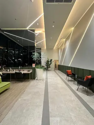 a lobby with chairs and tables in a building at New 1-Bedroom Condo for Rent 0 Meters from BTS Wutthakat in Bang Khun Thian