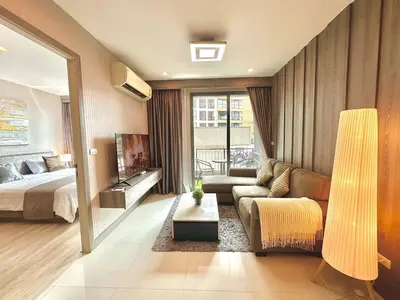 a living room with a bed and a couch at Bright & Spacious 1 BR - ASOKE in Bangkok