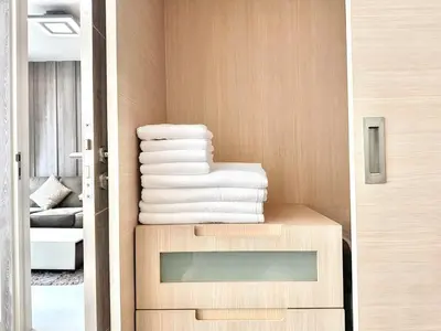 a stack of towels sitting on a table in a room at Bright & Spacious 1 BR - ASOKE in Bangkok