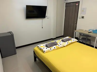 a hospital room with a yellow bed and a flat screen tv at 731 Hostel Victory Monument in Sathani Sam Sen