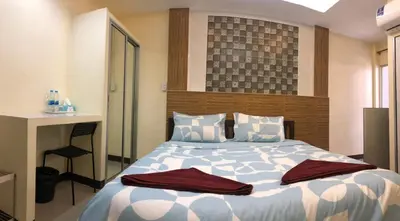 a bedroom with a large bed with a desk and a chair at 731 Hostel Victory Monument in Sathani Sam Sen