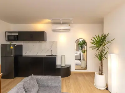 a kitchen and living room with a couch and a mirror at 2 Bedrooms for 3 guest comfy home at heart of Silom - 7A in Bangkok