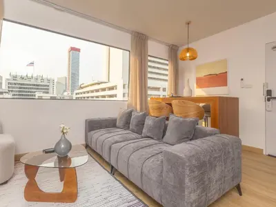 a living room with a couch and a large window at 2 Bedrooms for 3 guest comfy home at heart of Silom - 7A in Bangkok