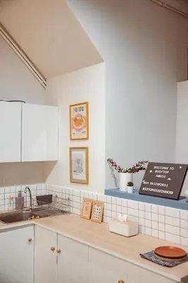 a kitchen with white cabinets and a sink at Spacious Relaxing Townhouse with Rooftop in Ekamai in Bangkok