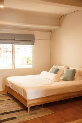 a bedroom with a large bed with a teddy bear on it at Spacious Relaxing Townhouse with Rooftop in Ekamai in Bangkok