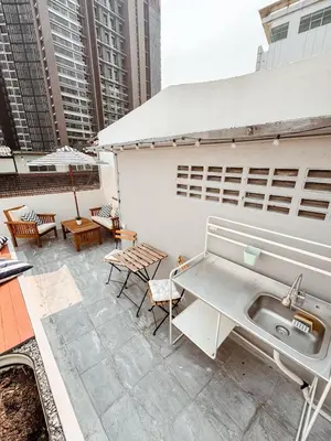 a patio with a sink and tables and buildings at Spacious Relaxing Townhouse with Rooftop in Ekamai in Bangkok